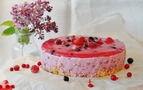 Berry soufflé cake on a table with lilacs