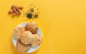 Cookies on a yellow background with sesame seeds and almonds