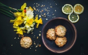 Cookies on the table with lemon and a bouquet of daffodils