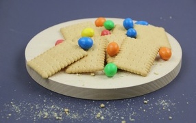 Печенье с разноцветными конфетами на сером фоне