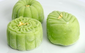 Зеленые конфеты на белой тарелке