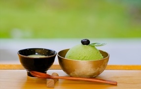 Зеленый шарик мороженого в чашке на столе