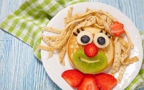 Pancakes with berries on a plate for a child