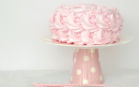 Розовый праздничный торт на столе
