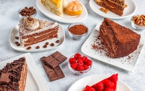 Сладкие куски торта на столе с шоколадом и ягодами