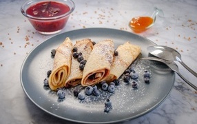 Thin pancakes with blueberries and powdered sugar