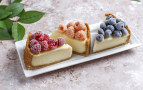 Three pieces of cheesecake with berries