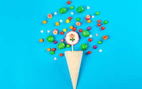 Waffle cone with sweets on a blue background