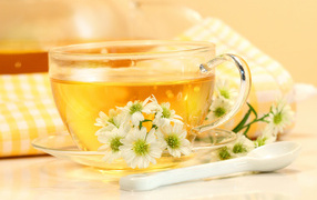 Cup of aromatic tea on a table with white flowers