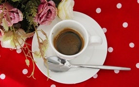 Cup of coffee on the table with rose flowers