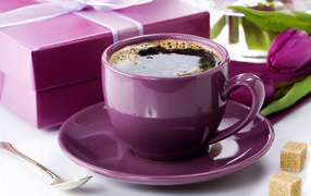 Чашка кофе с подарками и цветами на столе