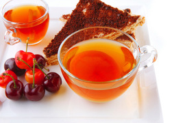 Чашка чая с тортом и ягодами черешни