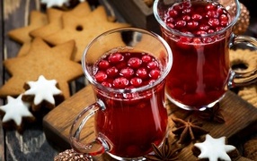 Two mugs of cranberry juice on the table with cookies