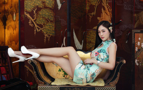 Красивая девушка азиатка лежит на диване