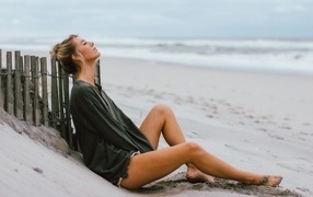 Романтическая девушка лежит на песке у моря