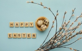 The inscription Happy Easter on a blue background with a willow branch and eggs