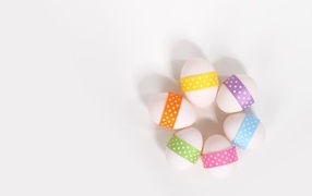 White eggs with ribbons on a white background