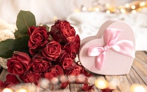 Heart-shaped box and bouquet of roses for a girl on March 8
