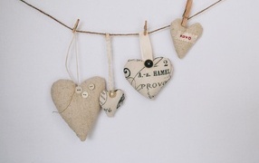 Fabric hearts on a rope on a gray wall