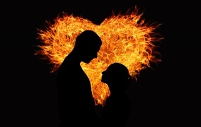 Silhouette of a couple in love against the background of a fiery heart