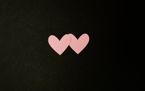 Two small pink hearts on a black background