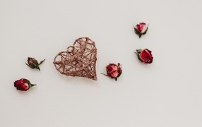 Плетеное сердце с сухими розами на сером фоне