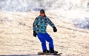 Male snowboarder going down the slope