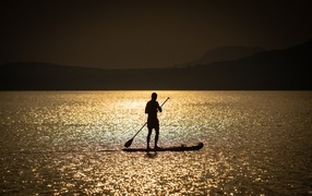 Мужчина серфингист в море на закате