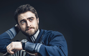 Actor Daniel Radcliffe in a sweater on a gray background