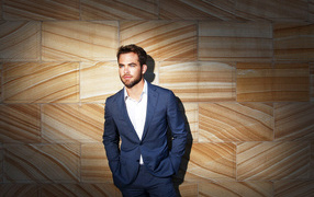 American actor Chris Pine in a suit near the wall