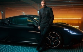 Footballer David Beckham in front of a black Maserati MC20
