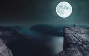 View of the big moon from the edge of a cliff