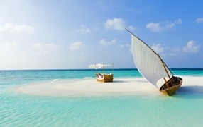 The boat stands on white sand near the blue ocean