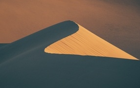 High sand dune in the rays of the scorching sun