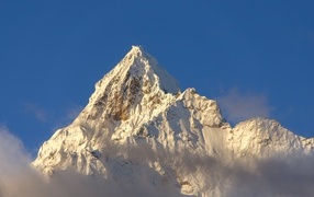 Steep snow-capped mountain peak on blue background