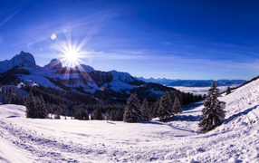 Яркое солнце освещает заснеженные альпы