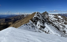 Вид на заснеженную гору под голубым небом