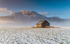 Деревянный дом в горах на снегу