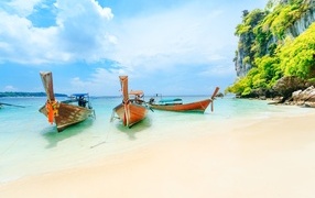 Boats stand on the shore of a tropical island in summer