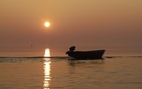 Лодка в море на закате солнца