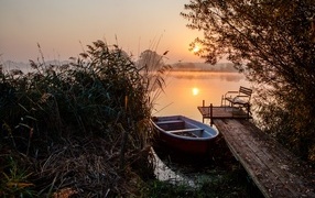 Лодка на берегу озера на закате 