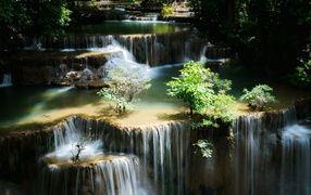 Водопад стекает по лесным порогам