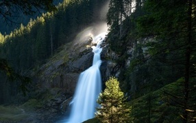 Водопад стекает по скале в лесу