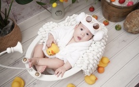 Ребенок в белой игрушечной ванной