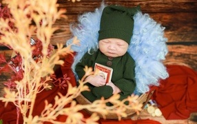 Baby sleeping in a suit with a book