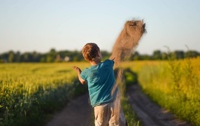 Boy throwing sand on the road