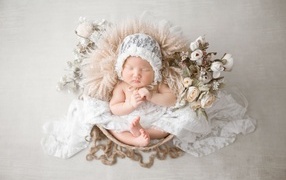 Милый спящий ребенок в белой шапке 