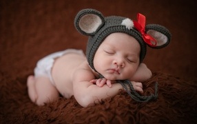 Смешная шапка на голове спящей малышки