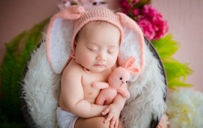 Забавный спящий ребенок обнимает игрушку