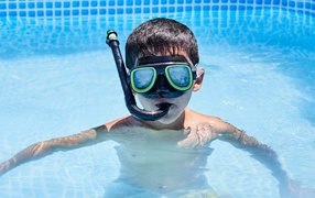 Little boy in a mask in the pool
